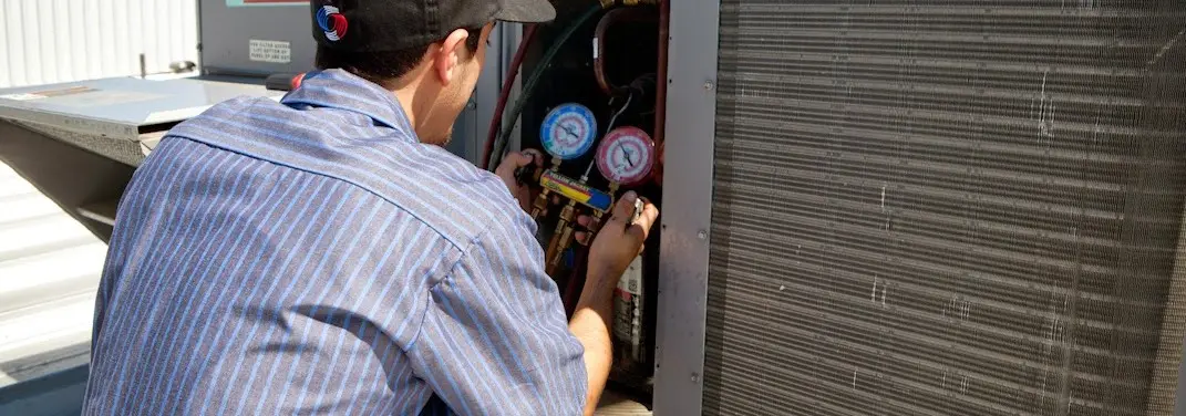 HVAC technician servicing a condenser unit in Miami Beach